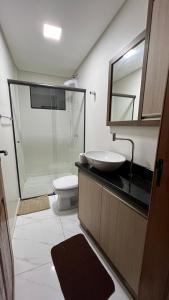 a bathroom with a sink and a toilet and a mirror at Apartamento em Pomerode - 203 in Pomerode