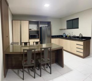 a kitchen with a table and a stainless steel refrigerator at Apartamento em Pomerode - 203 in Pomerode