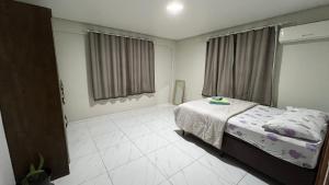 a bedroom with a bed and a large window at Apartamento em Pomerode - 203 in Pomerode