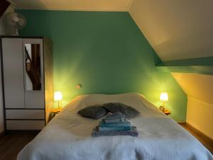 a green bedroom with a bed with towels on it at Bed en Bike Oudeschild in Oudeschild