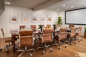 a conference room with a table and chairs and a projection screen at Claramount Club in Picton