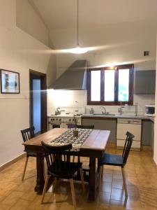 a kitchen with a wooden table and chairs in a kitchen at Chacra Los Cipreses - Casa completa con gran parque arbolado, 6 personas, entorno tranquilo in Cinco Saltos