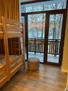 a bedroom with a bunk bed and a balcony at Nino's Home in Bakuriani