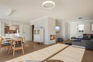 a kitchen and living room with a table and a fireplace at Sylter Inselglück in Wenningstedt
