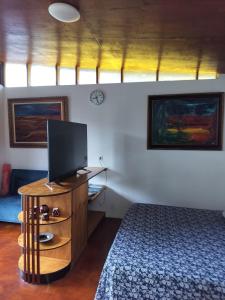 a bedroom with a bed and a flat screen tv at Vaianae Sands in Haapiti