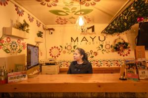 a woman standing behind a counter in a store at Mayu Boutique Hotel in Cusco