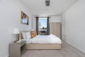 a white bedroom with a large bed and a window at The Oasis in Stonewood
