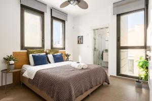 a bedroom with a large bed with blue pillows at Luxury Beachside 3BR with Balcony in Tel Aviv