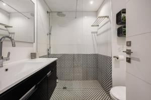 a white bathroom with a sink and a toilet at Luxury Beachside 3BR with Balcony in Tel Aviv +27 photos