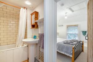 a bedroom with a bed and a sink and a tub at 2 Bed in Little Petherick oc-w28425 in Little Petherick