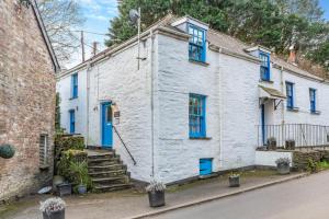 a white brick house with blue windows and blue doors at 2 Bed in Little Petherick oc-w28425 in Little Petherick