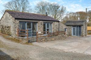an old stone house with a wooden fence in front at 1 Bed in Windermere oc-f31665 in Crook