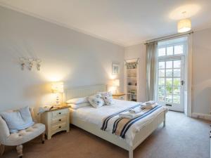 a bedroom with a bed and a chair and a window at 3 Bed in Ambleside oc-62587 in Far Sawrey +25 photos
