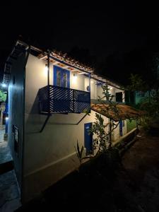 a white building with a balcony at night at Pousada Dom Luiz in Ouro Preto