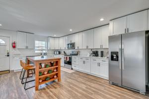 a large kitchen with white cabinets and a wooden table at 1 Mi to MGM Springfield: Cozy Winter Duplex! in Springfield