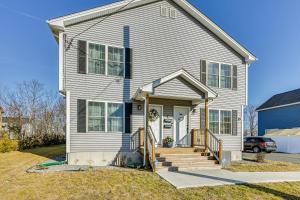 a white house with a porch and a driveway at 1 Mi to MGM Springfield: Cozy Winter Duplex! in Springfield