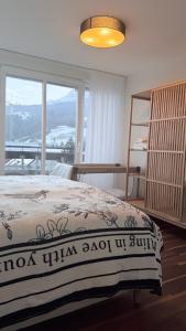 ein Schlafzimmer mit einem Bett und einem großen Fenster in der Unterkunft View Pilatus-Luxus-Maisonette mit Pilatusblick - 6 Personen - PP in Luzern