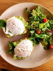 a plate with two eggs and a salad on it at Casa Nuestra Hotel Boutique y Experiencias para Compartir in Malinalco