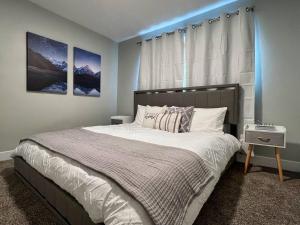a bedroom with a large bed with a blue light at Sun & Snow Bungalow Remodeled Hot Tub W&D in South Salt Lake