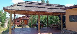 a large wooden pavilion with a thatched roof at La Posada de Daro in Cacheuta