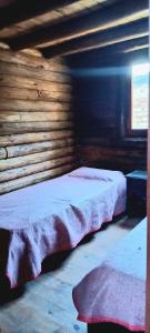 a bedroom with two beds in a log cabin at La Posada de Daro in Cacheuta
