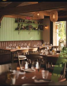 a restaurant with wooden tables and chairs and lights at le moulin de l oliveraie in Blausasc