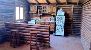 a kitchen in a log cabin with a refrigerator at La Posada de Daro in Cacheuta