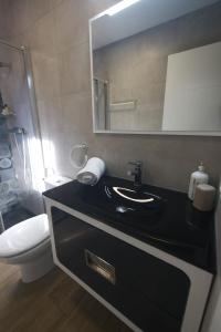 a bathroom with a black sink and a toilet at Apartamentos turísticos ilusiones in Cazalla de la Sierra +4 photos