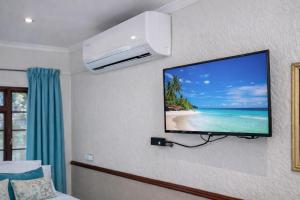 a flat screen tv hanging on a wall in a room at Lodge At The Link in Kempton Park