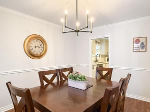 a dining room with a table and a clock on the wall at The Promenade Cottage License # 002-2023 in Niagara-on-the-Lake +42 photos