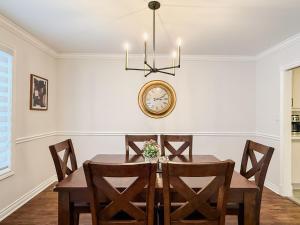 a dining room with a table and a clock on the wall at The Promenade Cottage License # 002-2023 in Niagara-on-the-Lake
