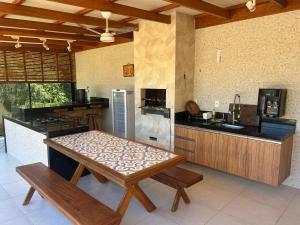a kitchen with a table and a counter top at Casa de alto padrão com piscina,quadra e jacuzzi em condomínio in Guarapari