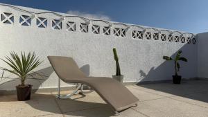 a chair sitting in front of a wall with plants at Tidmi Wave Anza in Agadir