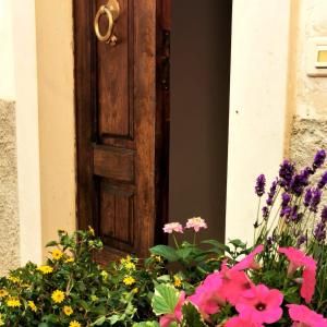 an open door with a bunch of flowers in front at Sotto le 3 Torri in Pacentro