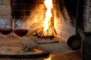 two glasses of wine in front of a fireplace at Sotto le 3 Torri in Pacentro
