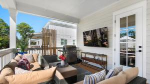 a porch with couches and a grill on a house at Harmony by the Bay in Santa Rosa Beach
