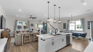 a kitchen and living room with white cabinets at Harmony by the Bay in Santa Rosa Beach