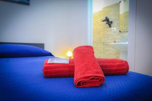 a red towel sitting on top of a bed at bed and fly near 2 fontanarossa 800mt aeroporto catania in CTA +19 photos
