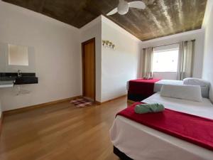 a bedroom with two beds and a red blanket at Mountain View Guesthouse: Peaceful Retreat near Tiradentes in Prados