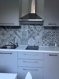 a white kitchen with a sink and a stove at Domus - Casa Vacanze in Cinquefrondi