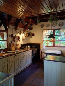 a kitchen with white cabinets and wooden ceilings and windows at Casa Patagónica con Vista al Lago y Jardín Ideal Familias en Bariloche in San Carlos de Bariloche
