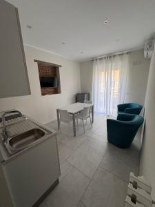 a kitchen with a sink and a table and chairs at Domus - Casa Vacanze in Cinquefrondi