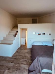 a bedroom with a bed and a staircase at Country House Tagliaferro in Marciana Marina