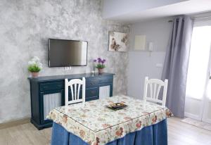 a dining room with a table and a tv at Apartamentos Turisticos Ilusiones 2 in Cazalla de la Sierra