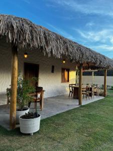 a hut with a table and a straw roof at suite elegante fullhausi 02 in Fortim