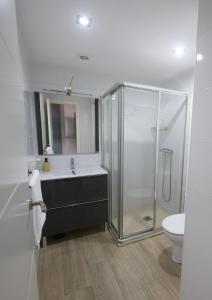 a bathroom with a shower and a sink and a toilet at Apartamentos Turisticos Ilusiones 2 in Cazalla de la Sierra
