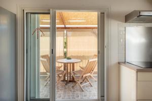 a kitchen with a table and chairs and a door at Résidence tamarin in Rivière +14 photos