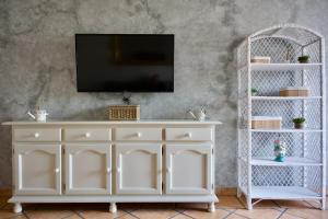 a white entertainment center with a tv on top at Apartamento turísticos ilusiones 1 in Cazalla de la Sierra