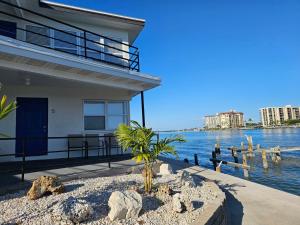 a house by the water with a palm tree at By the Beach Rentals in Clearwater Beach