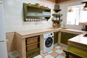 a kitchen with a washer and a washing machine at Apartamento turísticos ilusiones 1 in Cazalla de la Sierra
